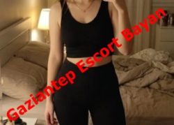 Promotional photo of a woman in a black outfit standing in a dim bedroom with a red text overlay reading 'Gaziantep Escort Bayan'.