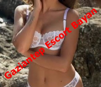 Woman in white lace lingerie standing outdoors with arms crossed, red diagonal text overlay reading 'Gaziantep Escort Bayan'. Woman in white lace lingerie standing outdoors with arms crossed, red diagonal text overlay reading 'Gaziantep Escort Bayan'.